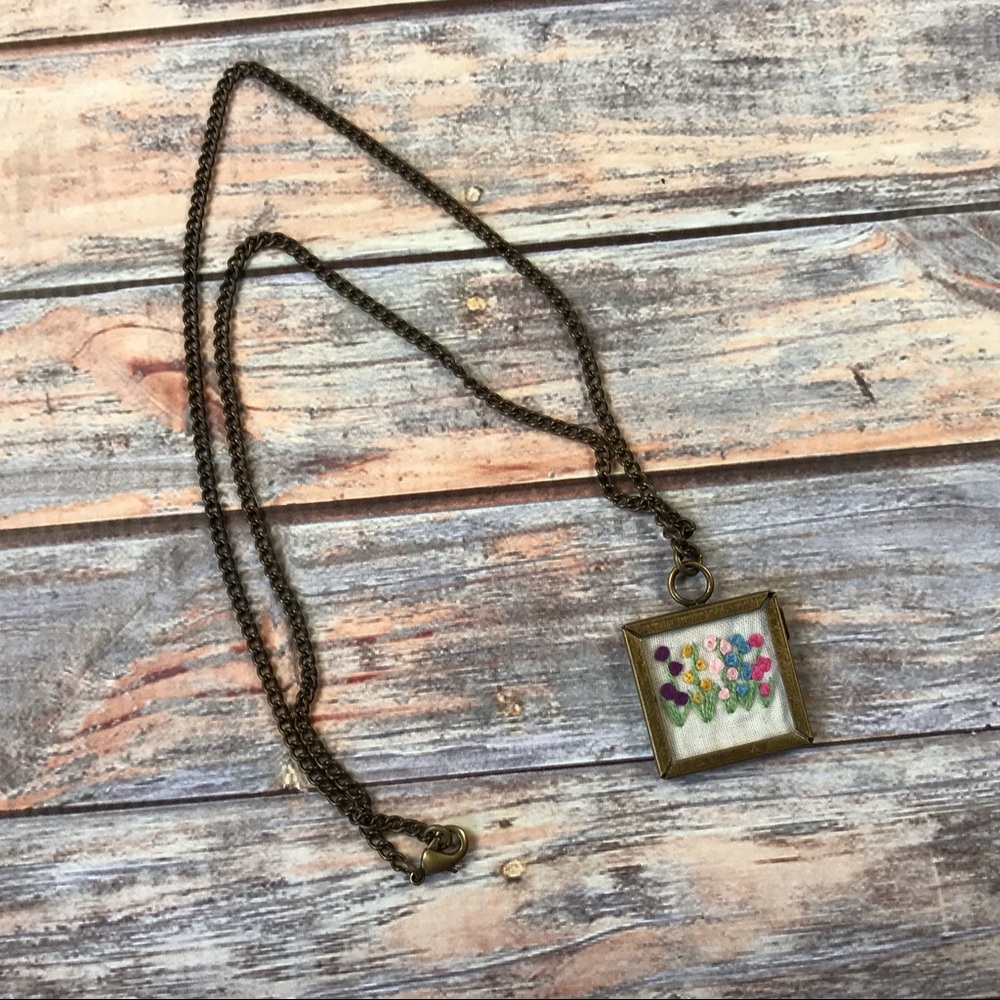 Framed embroidered flower pendant